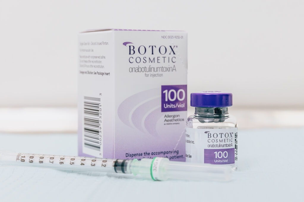 Botox box and bottle on table beside empty syringe